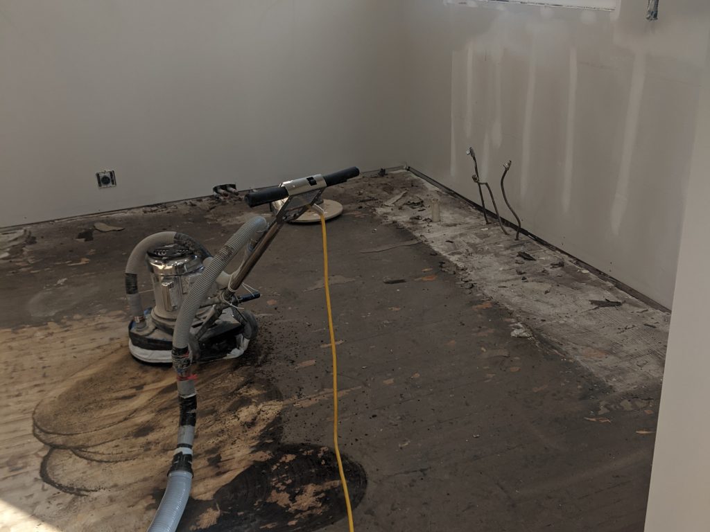 A floor being refinished with a machine.