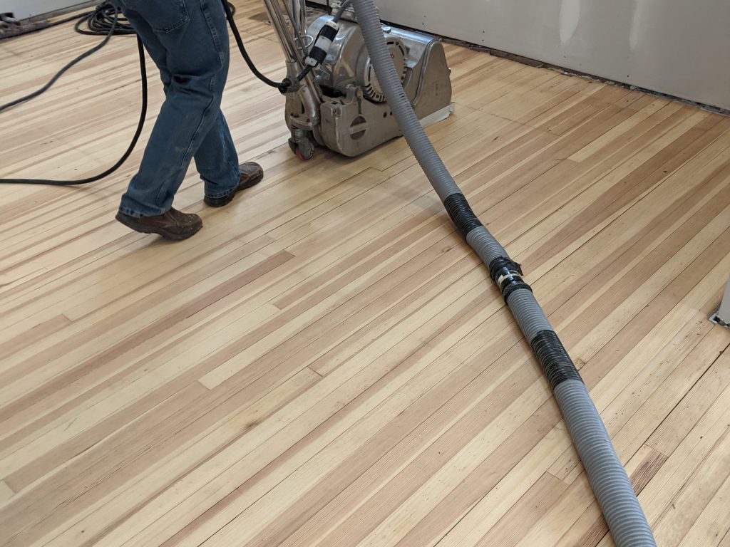 A person is vacuuming the floor of a room.