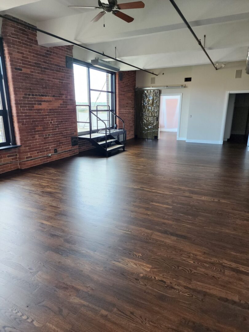 A room with wooden floors and brick walls.