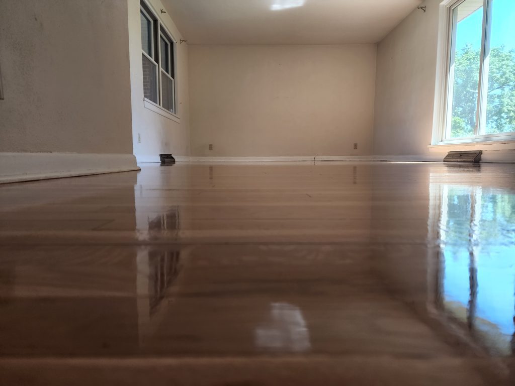 A room with hard wood floors and a window.