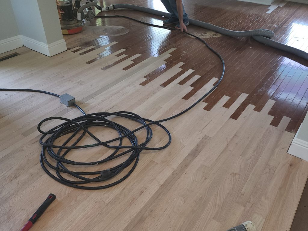 A water damaged floor with wires hanging from it.