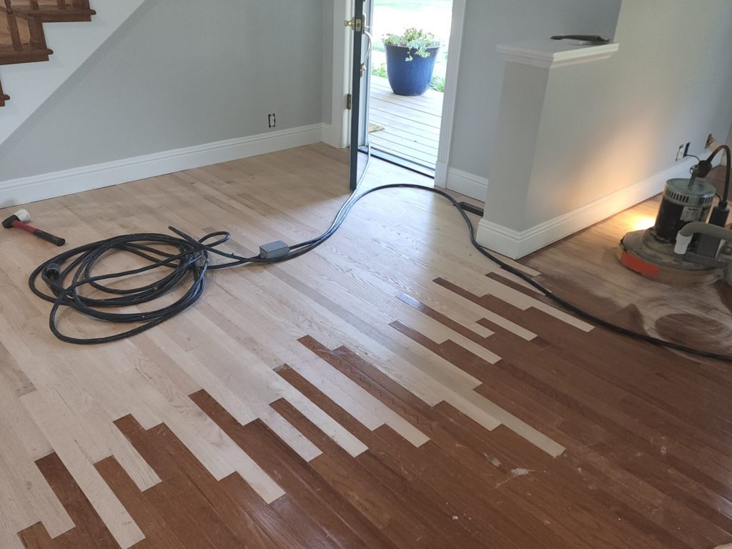 A room with wood floors and a hose connected to it.