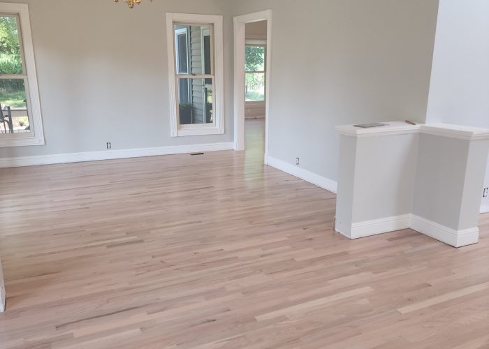 A room with hard wood floors and white walls.