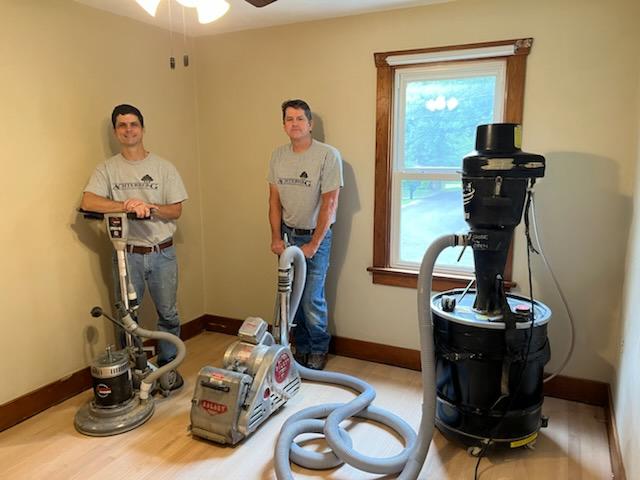 Two men standing in a room with equipment.